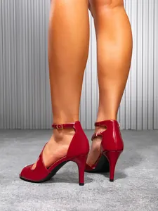 Detailed close-up view of elegant red patent leather stiletto sandals with ankle straps