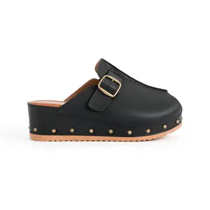 Vue latérale détaillée de mules noires à plateforme avec boucle dorée et clous