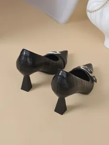 Vue arrière détaillée d'escarpins noirs à effet croco et talon géométrique moderne