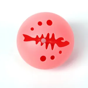 Vista detallada de una pelota de juguete para gatos rosa luminosa con diseño de espina de pez
