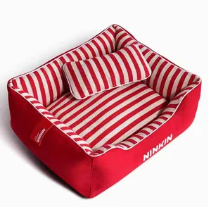 Detail of a cozy red and white striped rectangular pet bed with matching small pillow