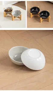 Macro detail of glossy ceramic pet bowls with ergonomic slanted opening and sturdy bamboo stand