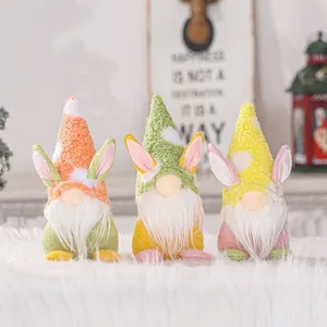 Three cute Easter bunny gnomes with white beards and pastel hats for home decoration.