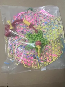 Colorful bird toy with bamboo weave and shredded paper, packaged for birdcage use.