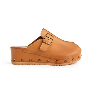 Sandale mule à plateforme marron avec clous métalliques et boucle sur fond blanc.