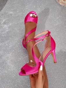 Detail of hot pink satin stiletto sandals with crisscross straps and open toe design