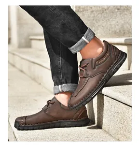 Detailopname van bruine veterwerkschoenen voor heren gedragen op een stenen trap.