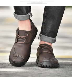 Detailopname van bruine lederen outdoor werkschoenen voor heren met stiksels.
