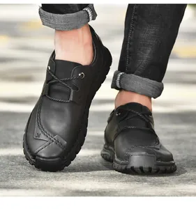 Detail van zwarte herenschoenen voor buiten met robuuste rubberen zool en veters