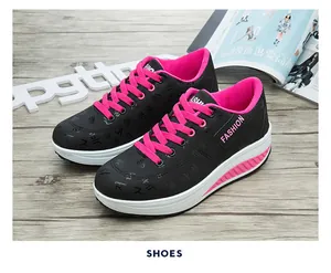Dettaglio laterale di sneaker platform nere e rosa con spessa suola ondulata e decorazioni.