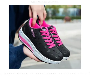 Dettaglio ravvicinato di scarpe platform nere e rosa da donna con ricamo alla moda