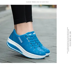Dettaglio scarpe platform blu con suola basculante, lacci e scritte alla moda