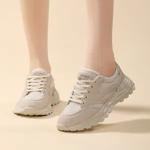 Dettaglio di sneakers beige da donna con mesh traspirante e suole spesse a onde.