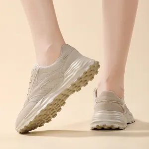 Primo piano di sneakers beige da donna con suola ondulata e tomaia in rete traspirante