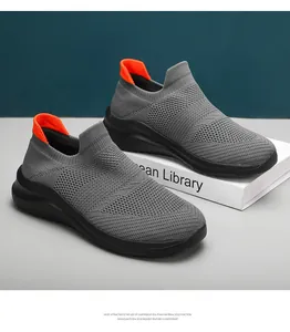 Detailed view of grey sock sneakers with orange heel tab and black EVA sole