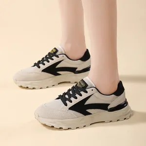Dettaglio ravvicinato delle sneakers chunky beige e nere da donna con motivo a freccia