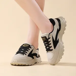 Primo piano di eleganti sneaker chunky da donna color albicocca e nero in studio.