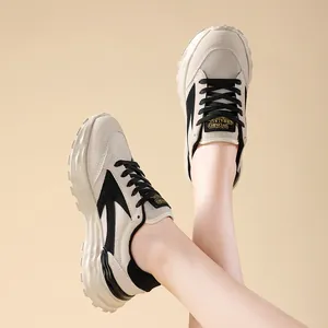 Primo piano di sneakers chunky da donna color albicocca e nero indossate da una modella