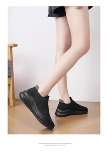 Detailed side view of lightweight black knit sock sneakers worn indoors.