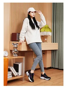 Mannequin asiatique élégant portant des baskets à coussin d'air tissées noires à la maison