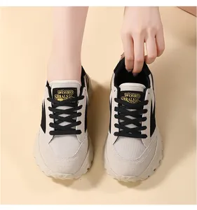 Primer plano de elegantes zapatillas beige y negras con suela gruesa en un modelo en un estudio