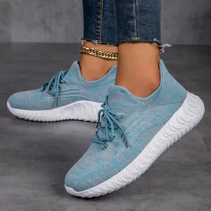 Detailed macro view of blue breathable knit women's running sneakers on grey tile floor