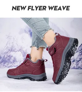 Detailansicht der bordeauxroten wasserdichten Winterstiefel mit Fleecefutter auf Schnee