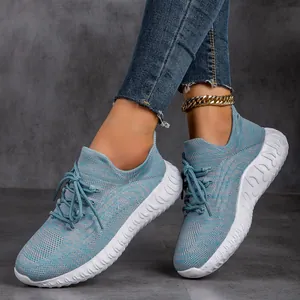 Detail view of lightweight breathable blue fly-knit sneakers worn by a model in casual setting