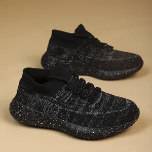 Detailed view of the breathable fly-knit mesh and speckled outsole on black running shoes