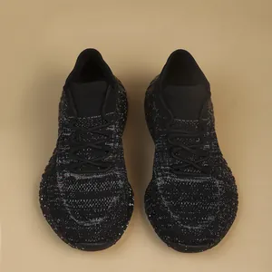 Top-down view of black fly-knit women's running shoes with white speckles