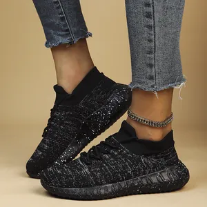 Detailed view of breathable flyknit women's sneakers in black with splatter sole pattern