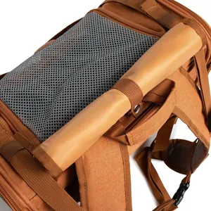 Primer plano de mochila marrón para mascotas con malla transpirable y solapa enrollable