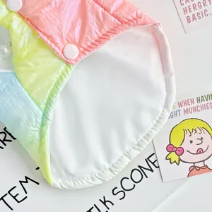 Detailaufnahme des weichen weißen Futters und der rosa Druckknöpfe der Regenbogen-Haustierweste.