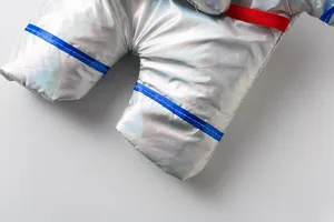 Close-up detail of silver metallic fabric on astronaut pet costume with blue trim