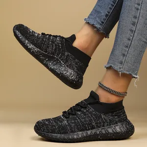 Detail of black breathable fly-knit sneakers featuring speckled slip-resistant soles