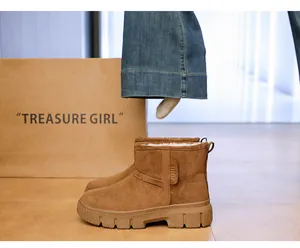 Detailed view of brown suede snow boots with thick faux fur lining and anti-slip sole.