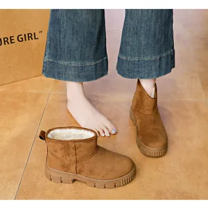 Detailed view of women's brown suede snow boots featuring thick faux fur lining and non-slip soles