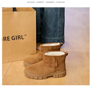 Detail of brown suede snow boots with thick white fleece lining and platform sole