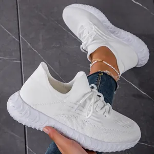 Detailed texture of lightweight white breathable fly-knit sneakers with laces close-up