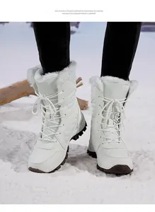 Detailed view of white fleece-lined mid-calf snow boots on a snow-covered ground