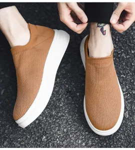 Detail of brown fly-knit slip-on loafers for men with breathable mesh upper.