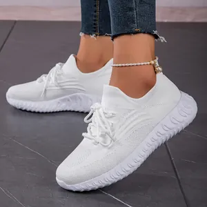Detailed side view of breathable white fly-knit sneakers with elegant lace-up closure
