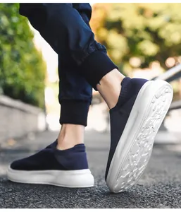 Man walking in navy blue breathable flyknit slip-on casual shoes outdoors