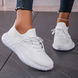Close-up side view of lightweight white breathable fly-knit lace-up sneakers for women