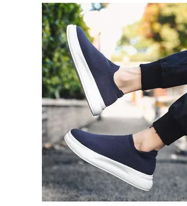Close-up of blue breathable knit slip-on men's sneakers in an outdoor street setting