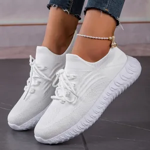 Close-up of white lightweight breathable flyknit lace-up sneakers on model