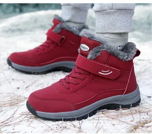 Macro view of red high-top winter boots with warm fleece lining on snowy ground