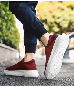 Detailed side view of breathable burgundy fly-knit men's slip-on sneakers with white sole