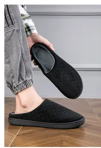 Detailed view of black indoor slippers featuring a textured upper and soft plush lining