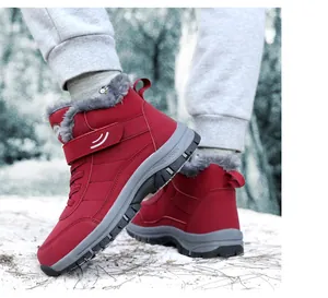 Close-up of red high-top winter boots with warm gray faux-fur lining and outdoor sole